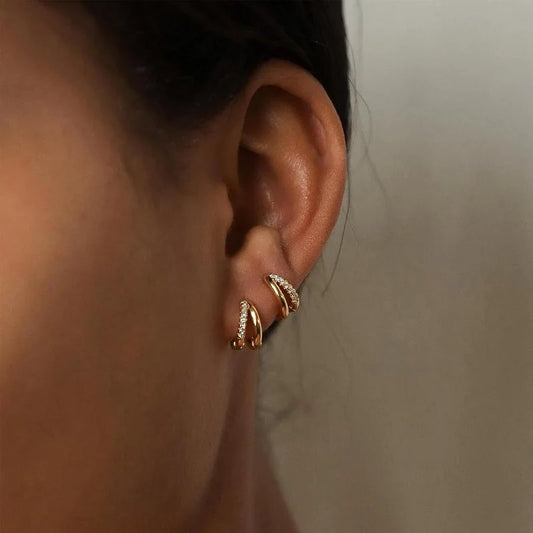 Gold double-layer huggie hoop earrings with crystal accents, side view on ear
