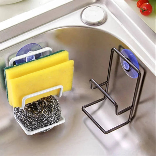 Black metal sink drain rack with suction sponge holder, holding sponges and drying.