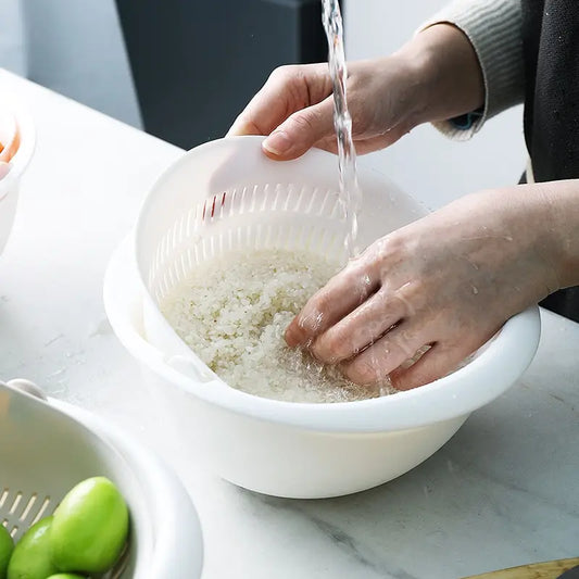 White double-layer draining basket; hands rinse a pale grain-like food inside