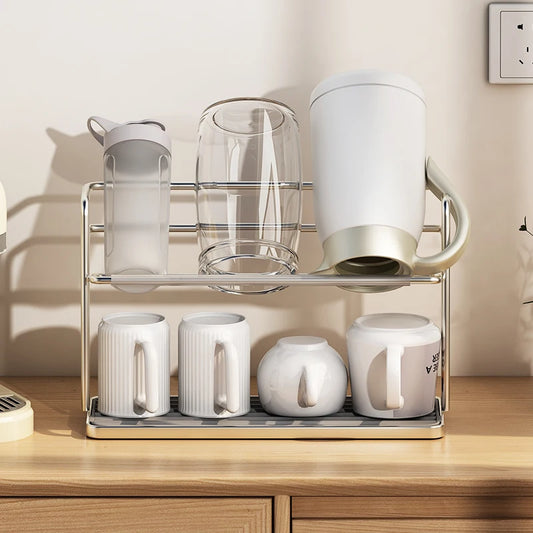 Stainless steel two-tier cup drying rack holding inverted teacups and a clear glass mug