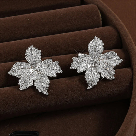 Silver leaf flower stud earrings with sparkling zirconia micropave, pair on display.