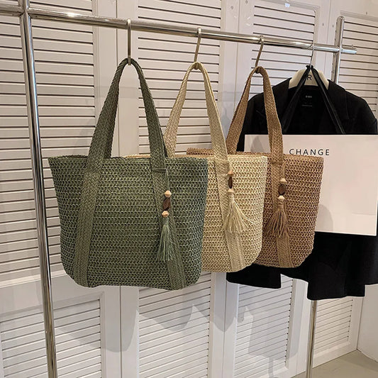 Set of woven straw tote bags in olive, beige, and khaki tones with tassel details