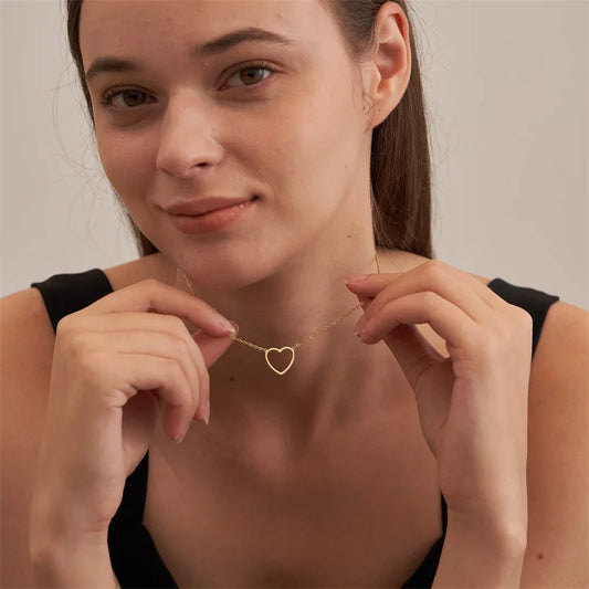 Gold-tone heart pendant necklace on model, fine chain with heart charm