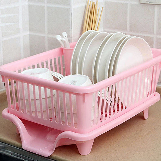 Pink countertop dish drying rack with drainer board, holding plates and stacked dishes