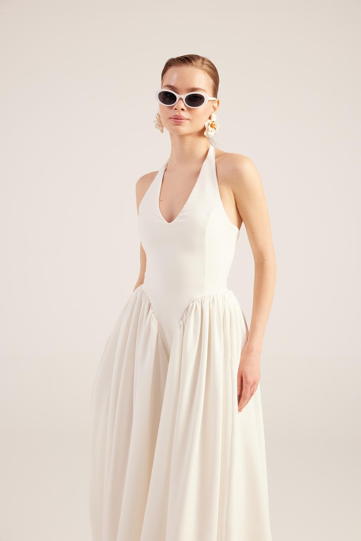 White sleeveless V-neck maxi dress with gathered bodice and full pleated skirt