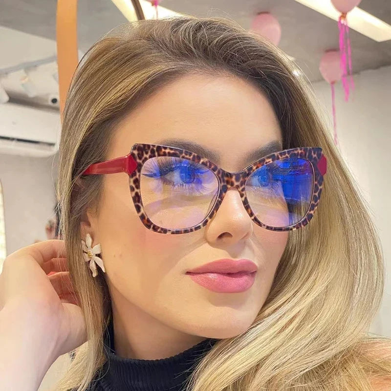 Oversized cat-eye reading glasses with red leopard frame and blue-tinted lenses