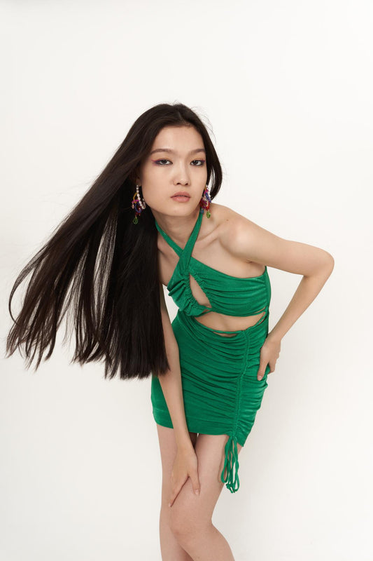 Green ruched mini bodycon dress with halter cutout and gathered side ties