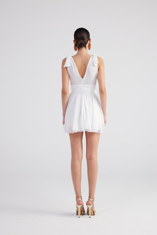 White ruched mini dress back view with V-neck cut and pleated skirt
