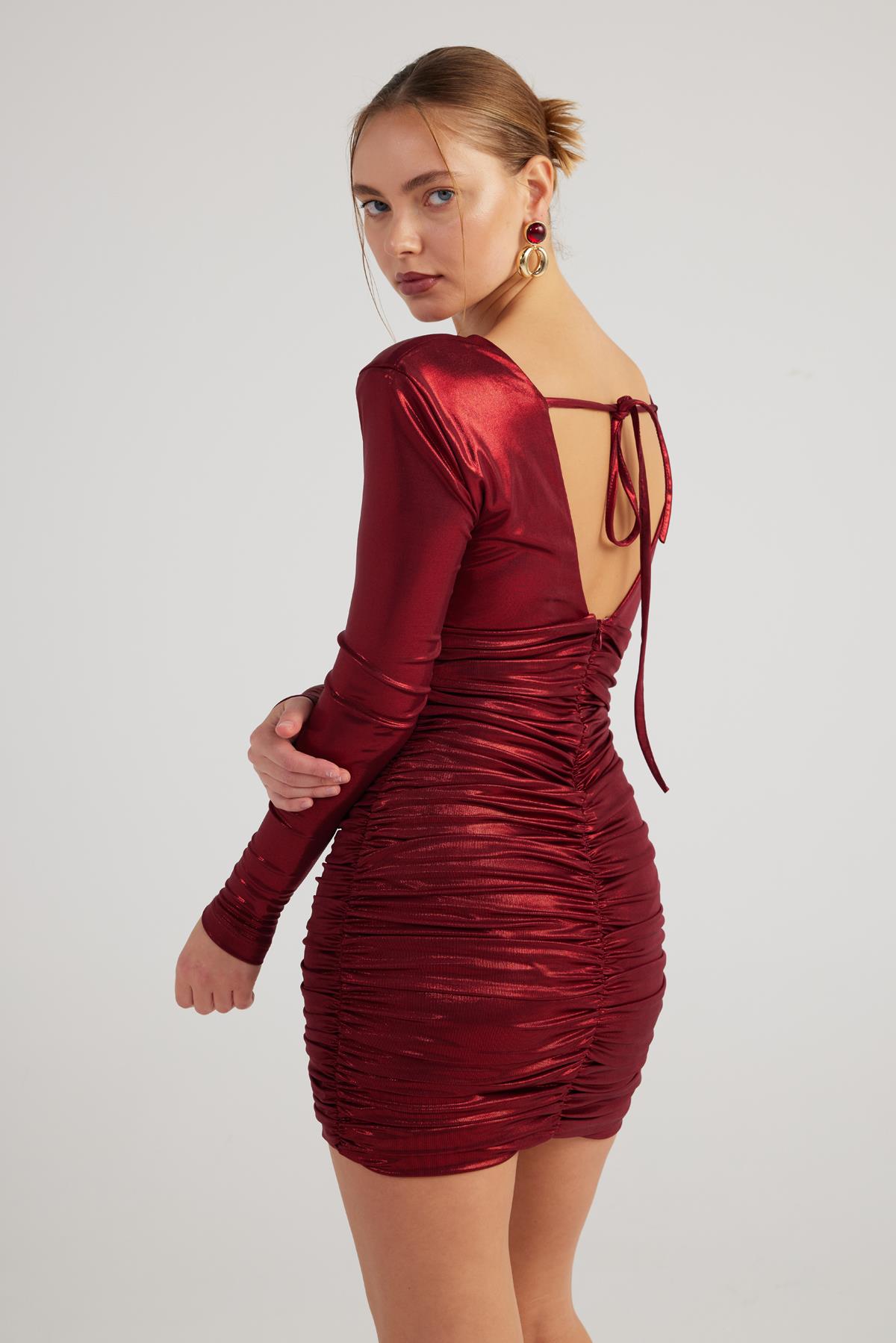 Burgundy shiny mini dress with long sleeves, deep V-neck, lace-up back