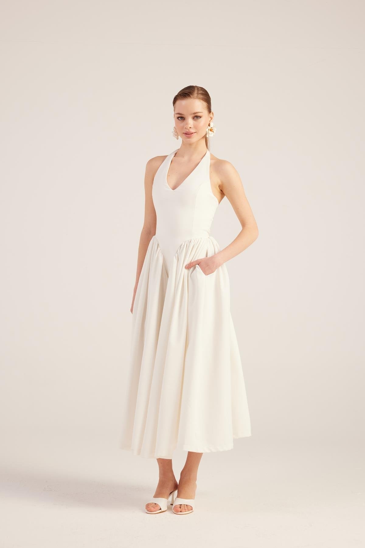 White sleeveless V-neck maxi dress with gathered waist and full pleated skirt