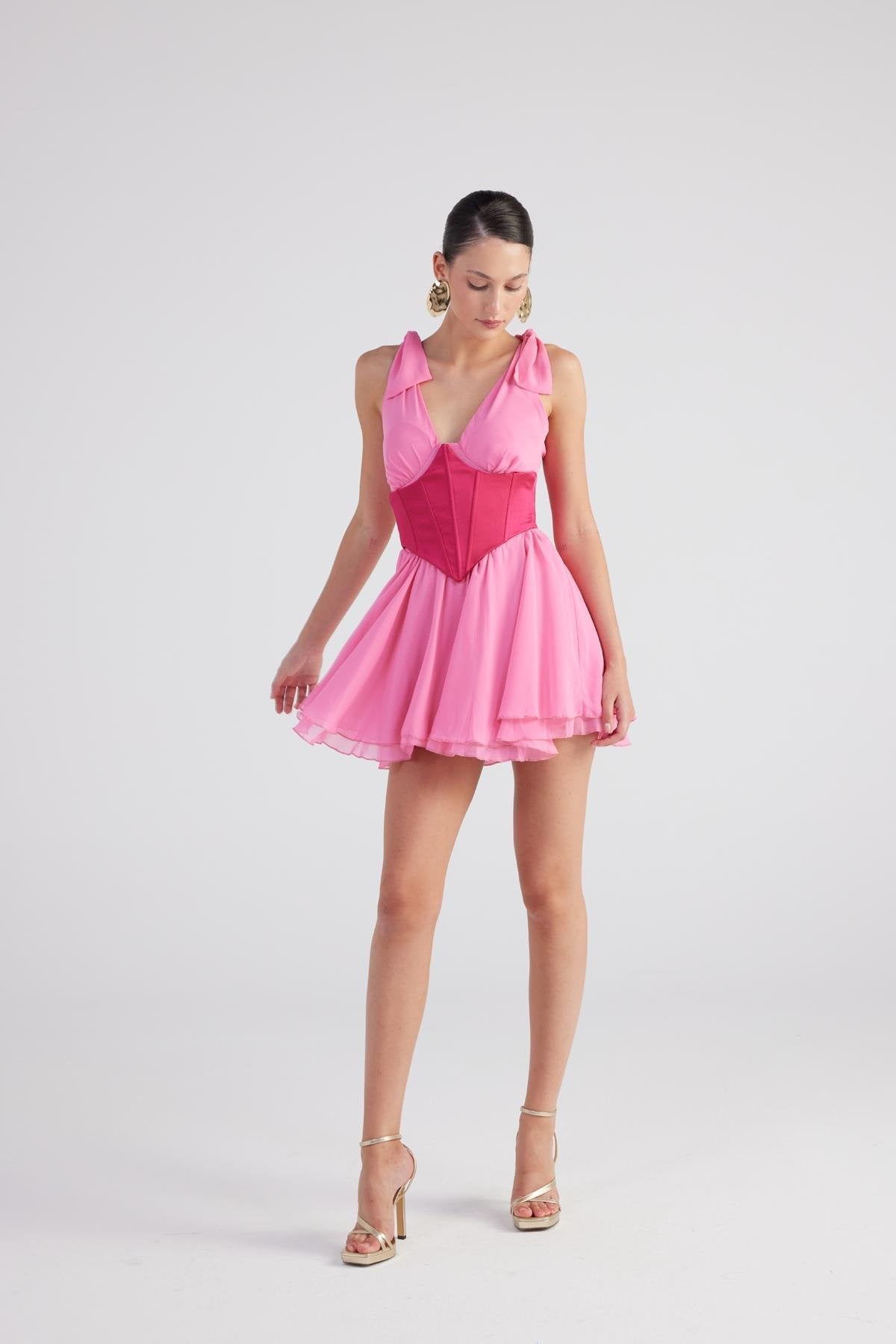 Pink sleeveless mini dress with ruched V-neck bodice and pleated tiered skirt