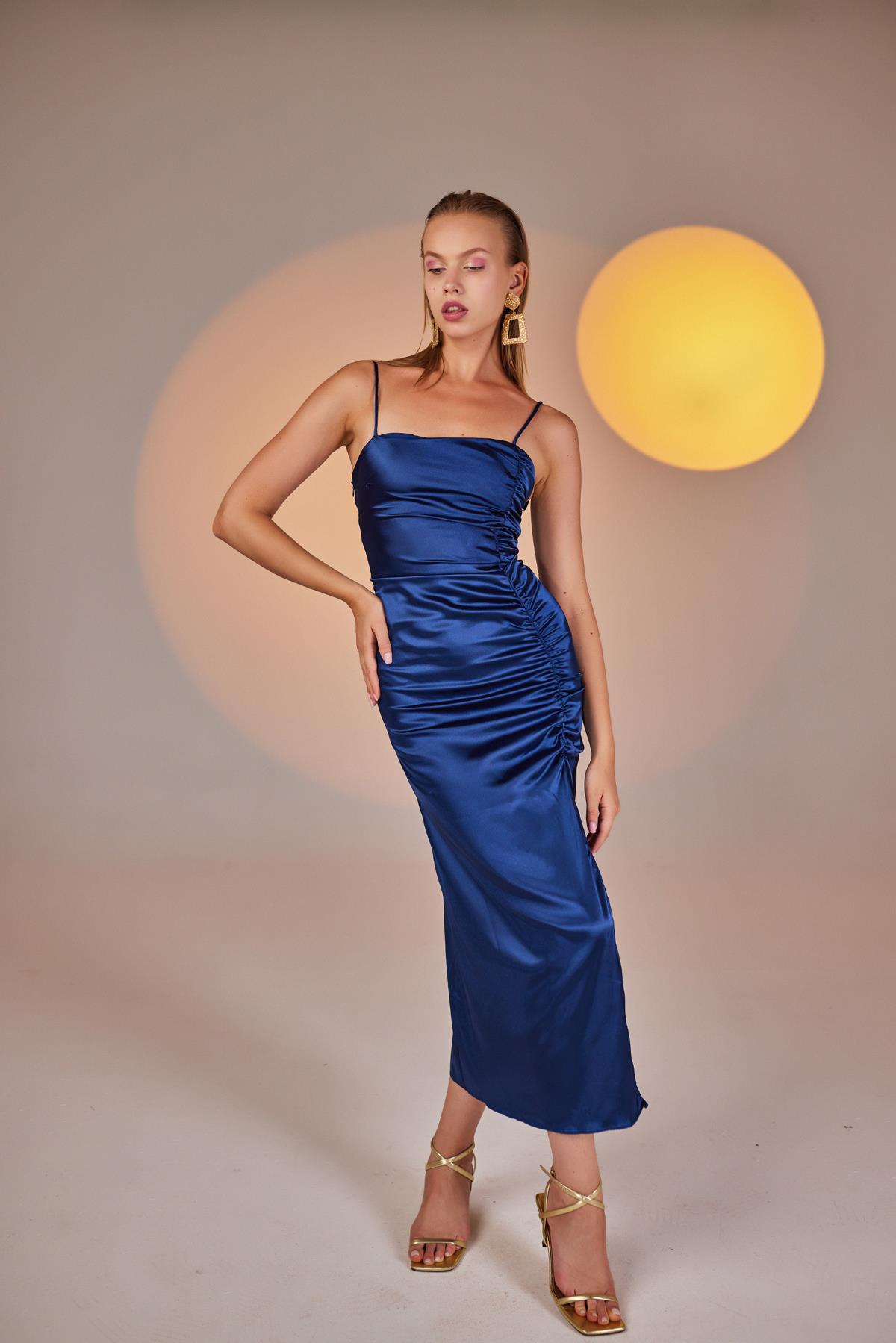 Blue ruched satin midi dress with spaghetti straps and front slit, standing front