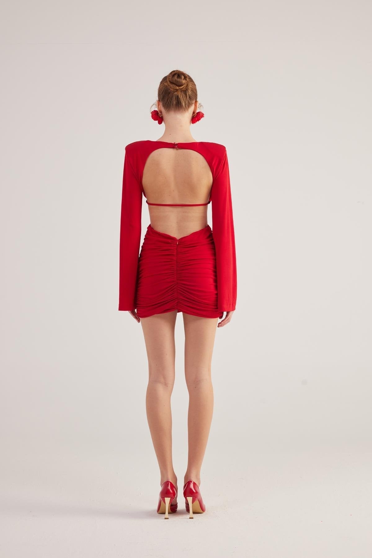 Red backless long-sleeve mini dress, ruched front with open back showing bare back