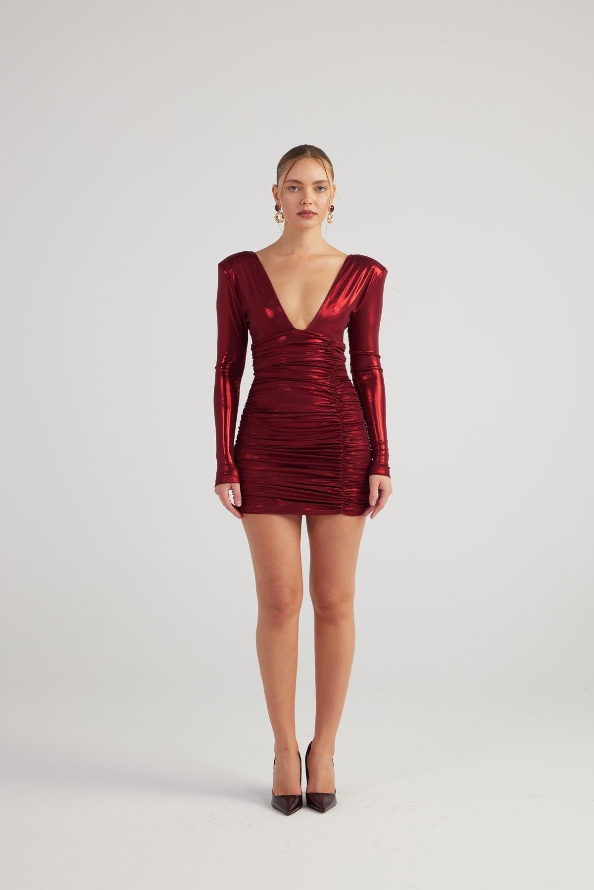 Burgundy shiny mini dress, long sleeves, deep V-neck, gathered body