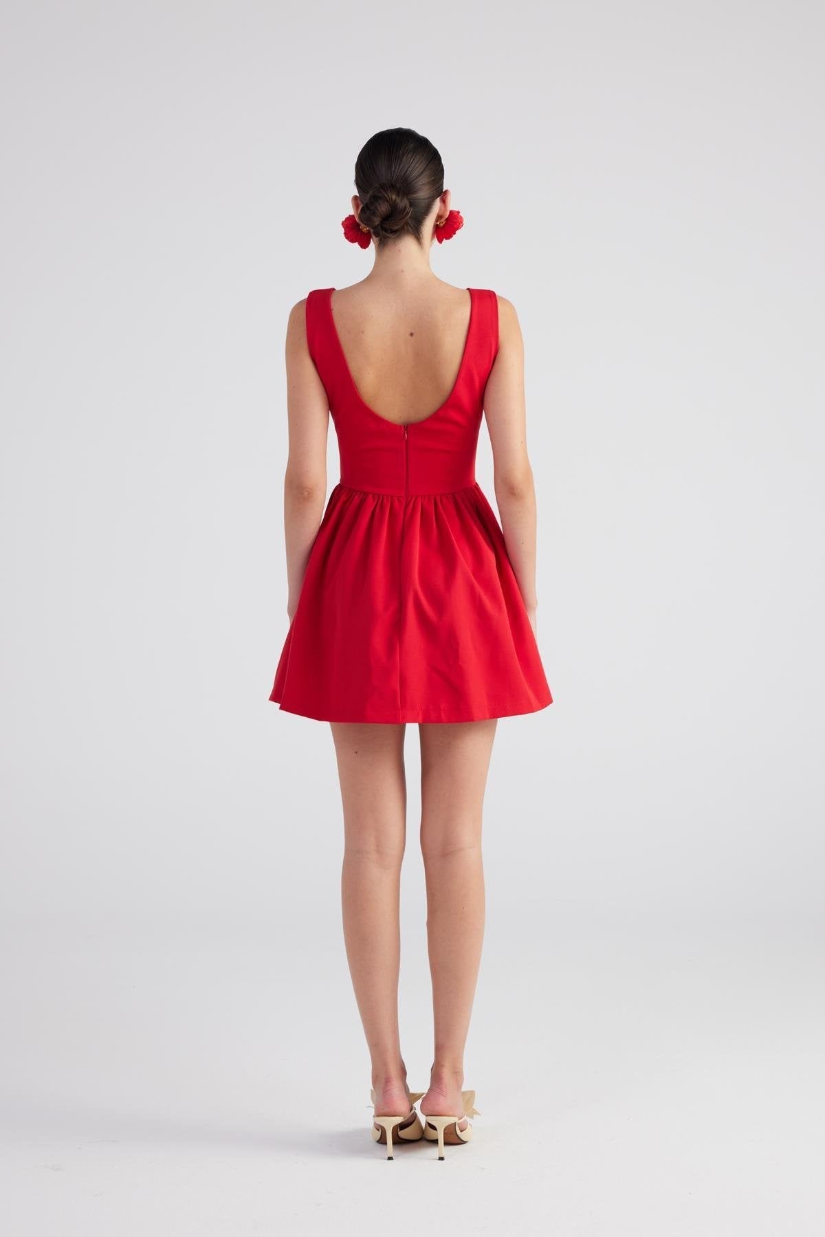 Red sleeveless pleated mini dress with open back and gathered waist