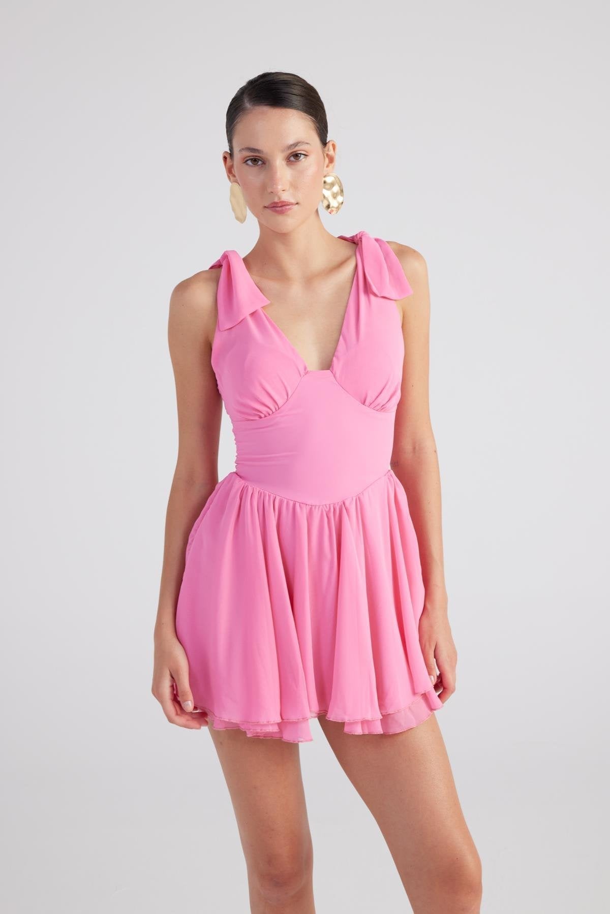 Pink sleeveless ruched mini dress with V-neck, ruffled shoulders and pleated skirt