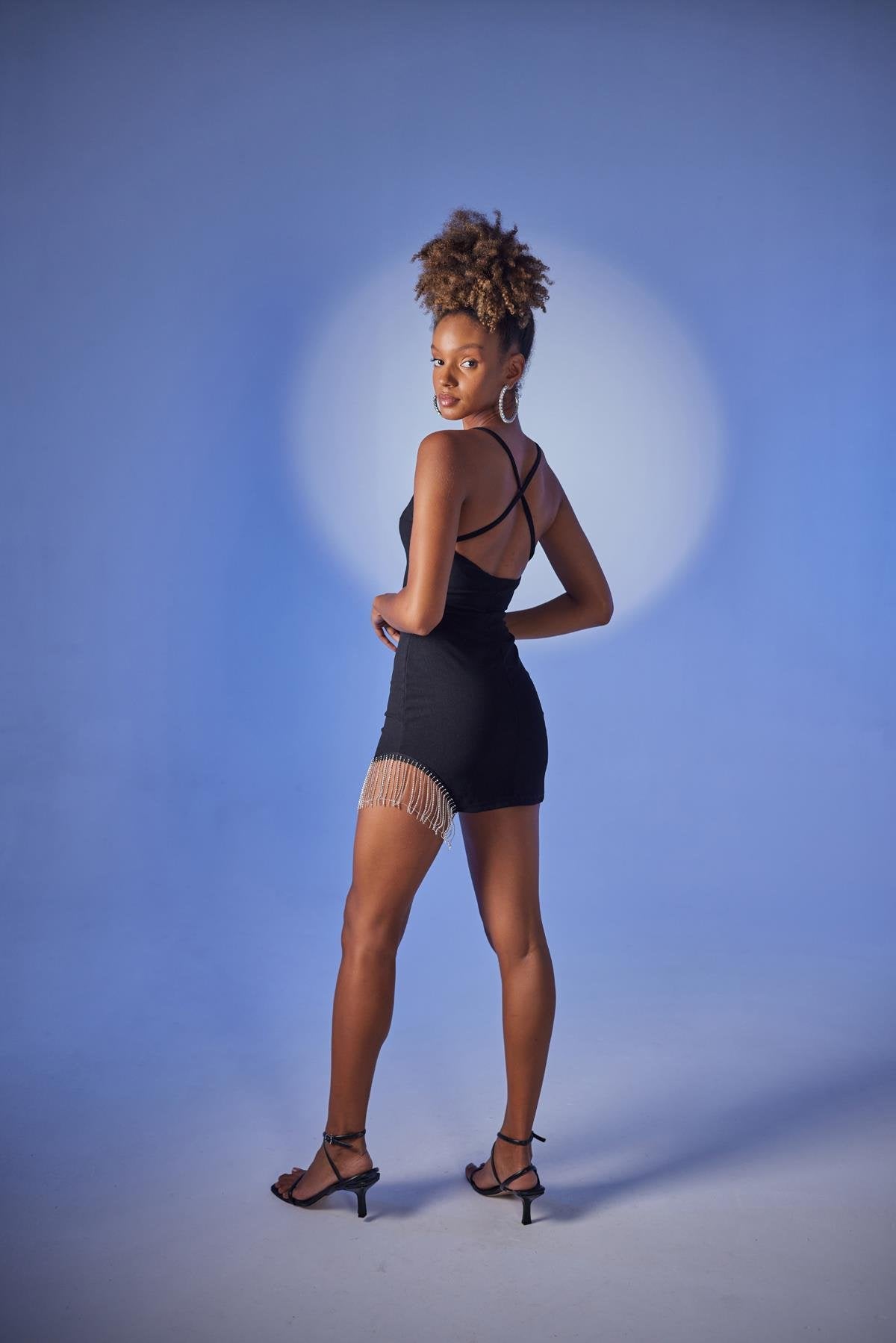 Black mini bodycon dress with crisscross back and chain accents at hem