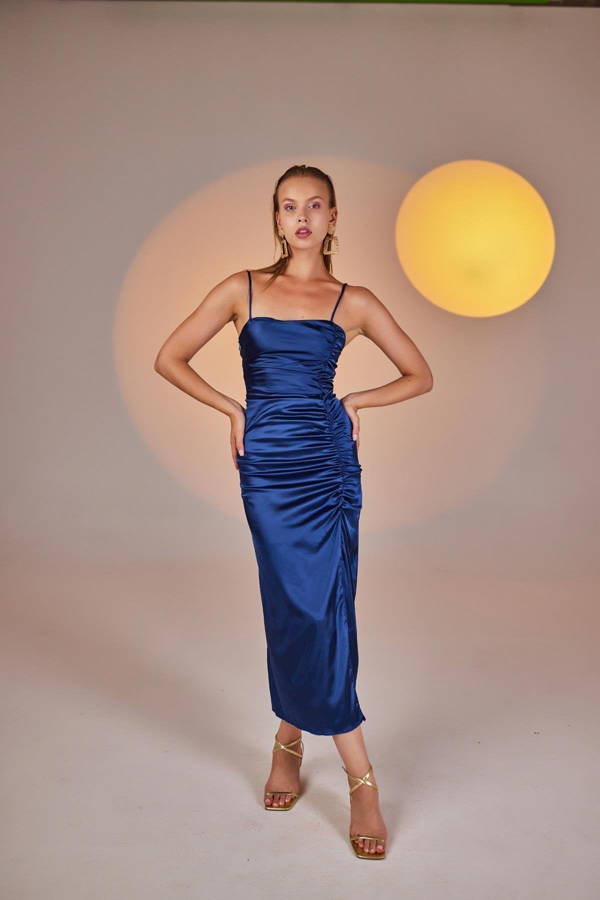 Blue ruched satin midi dress with spaghetti straps and front slit, full-body front