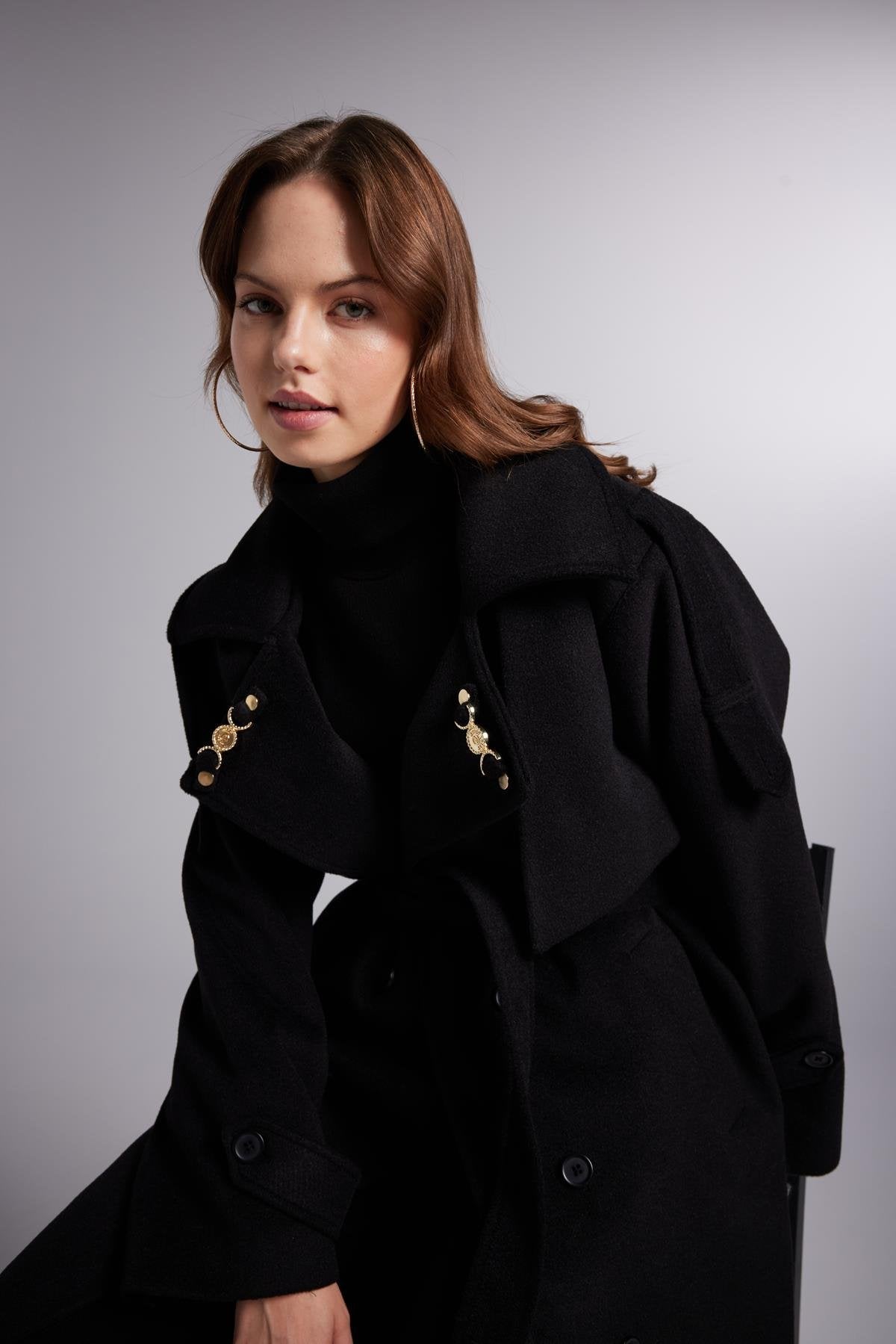 Black high-neck maxi coat with gold-tone embroidery on shoulders and chest