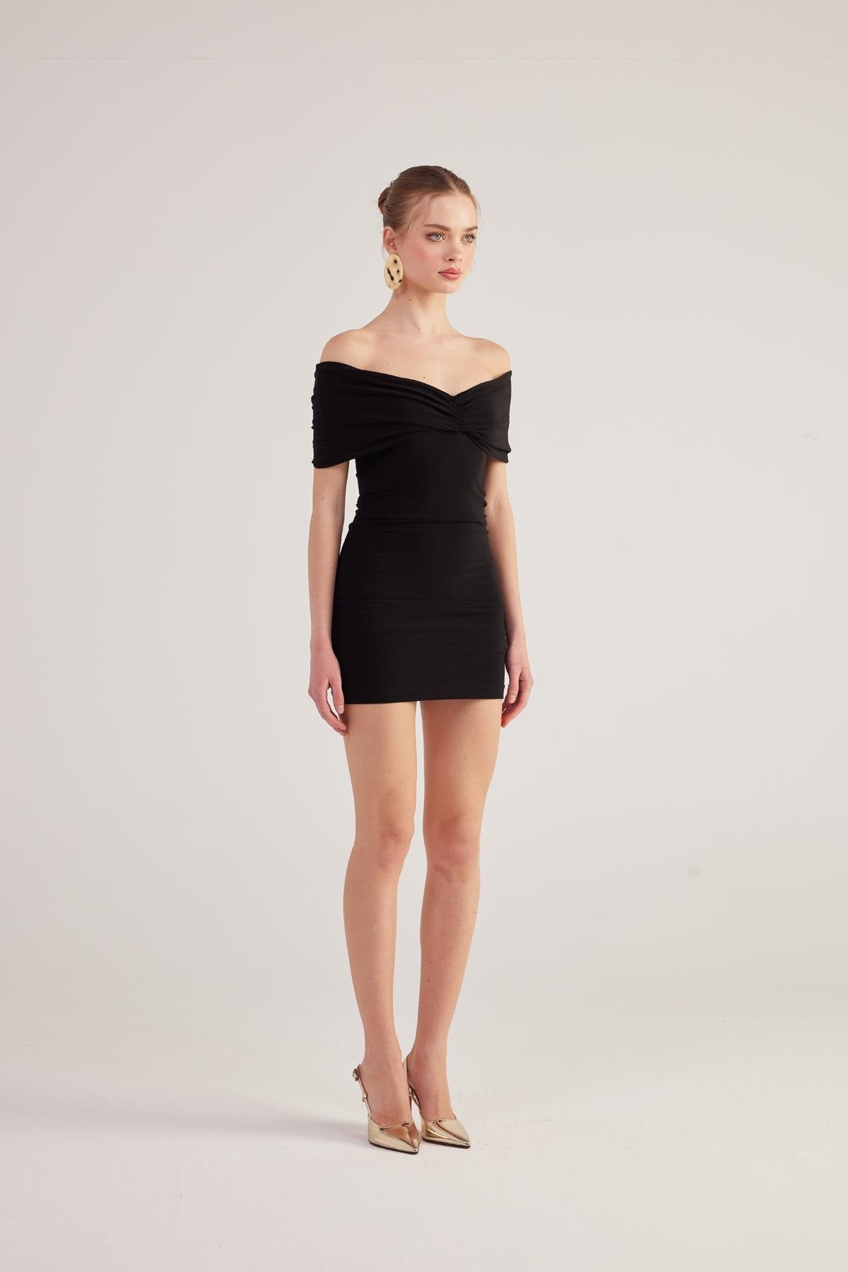 Black bardot mini dress in fitted silhouette with off-shoulder neckline and ruched detail