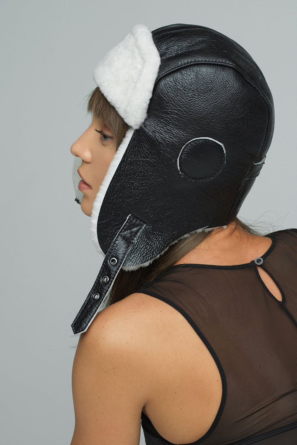 Lamb fur hat with black shearling leather ear flap and circular front detail