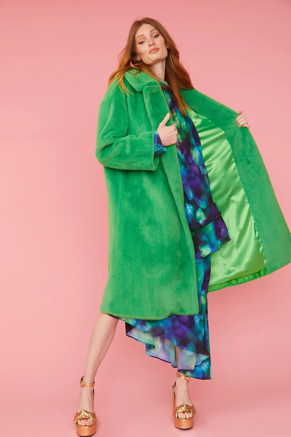Green faux fur maxi coat with hooded collar; reveals bright green lining