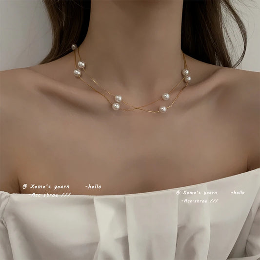 Gold-tone double-layer pearl string choker necklace on bare neck
