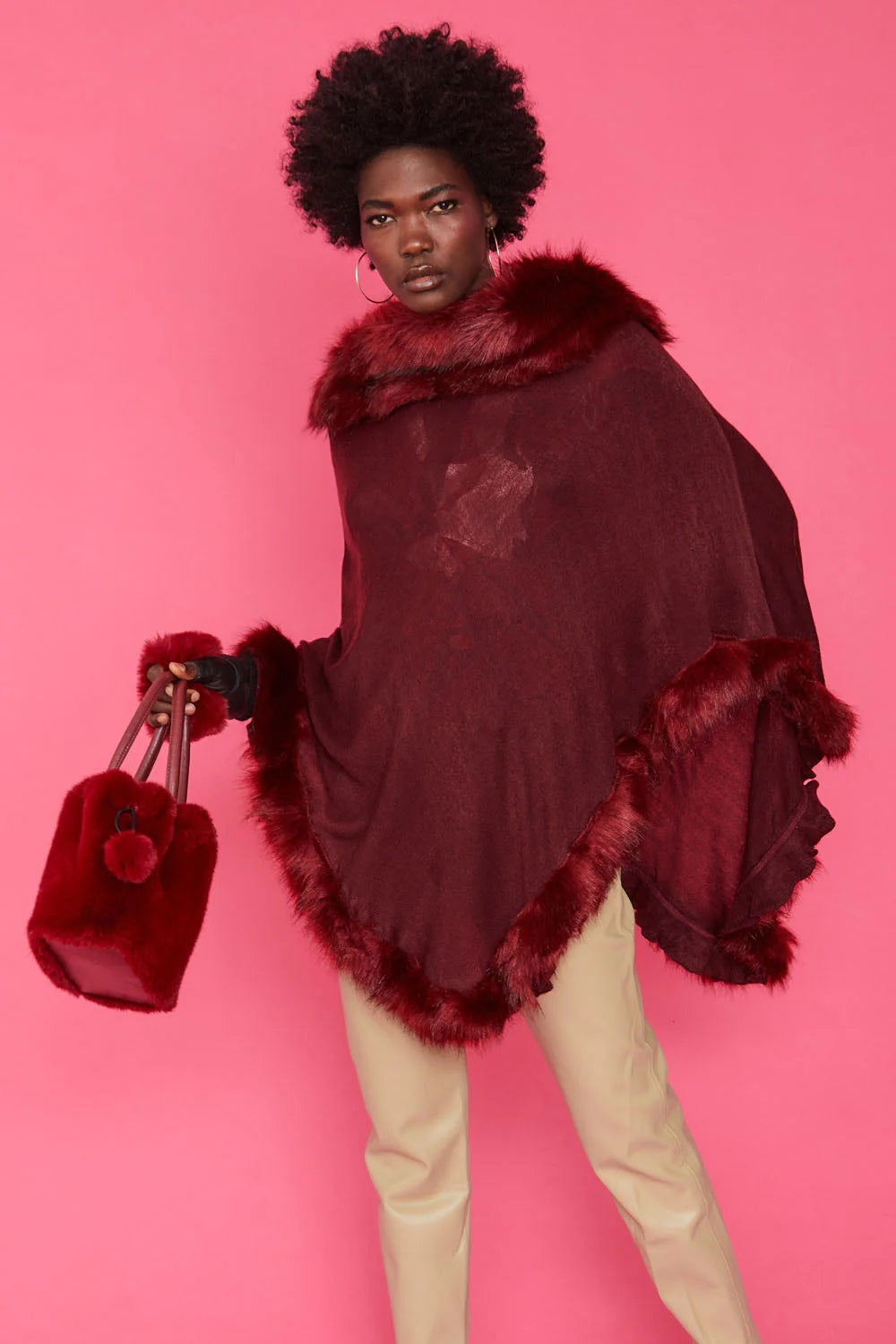 Red faux fur drawstring bucket bag with pom-pom charm, side view