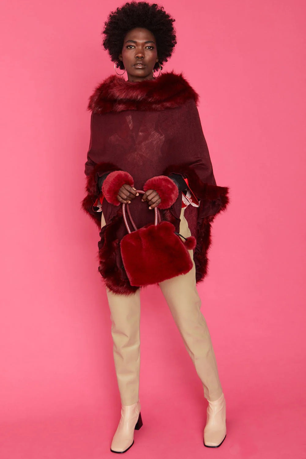 Red faux fur bucket bag with drawstring and pom-pom charm, front view
