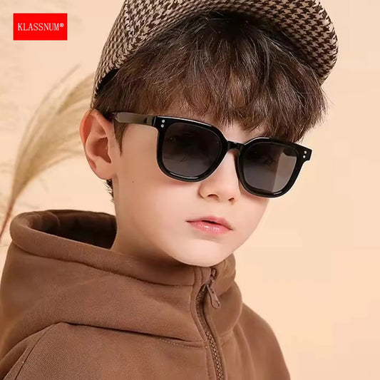 Kids black square sunglasses with dark lenses and thick frame, on a child