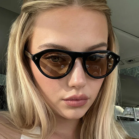 Black cat-eye sunglasses with brown tinted lenses and angular temple tips