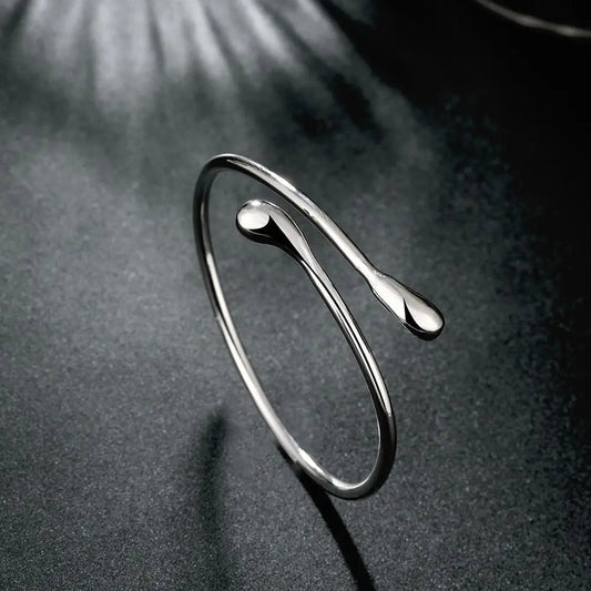 Polished silver water-droplet bangle bracelet with curved oval openwork