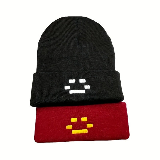 Black knit beanie with white pixel-face embroidery on folded cuff