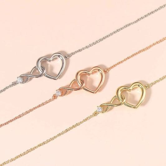 Heart infinity chain bracelets in silver, rose gold, and gold tones with heart charms