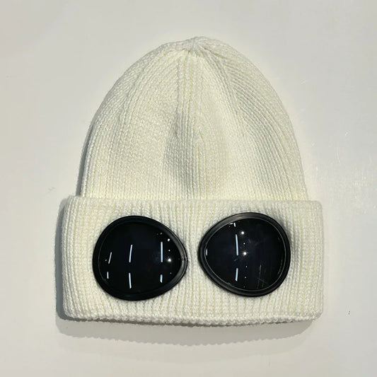 White knitted beanie hat with two round black goggle lenses on front