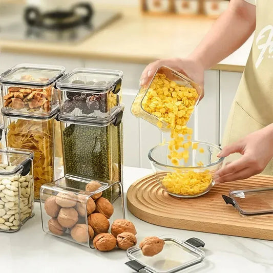 Clear cereal storage jar with black lid, shown filling dry snacks from a hand