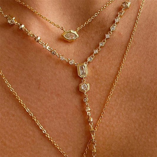 Gold-tone zircon pendant necklace with geometric charm cluster and short chain drop