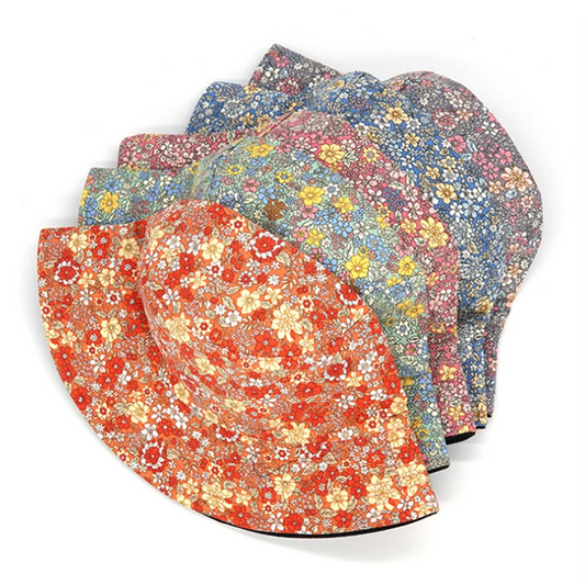 Reversible floral bucket hats stacked, showing orange, blue, pink, and gray prints