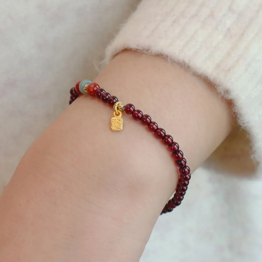 Garnet beaded bracelet with gold charm and small round multicolor bead accents