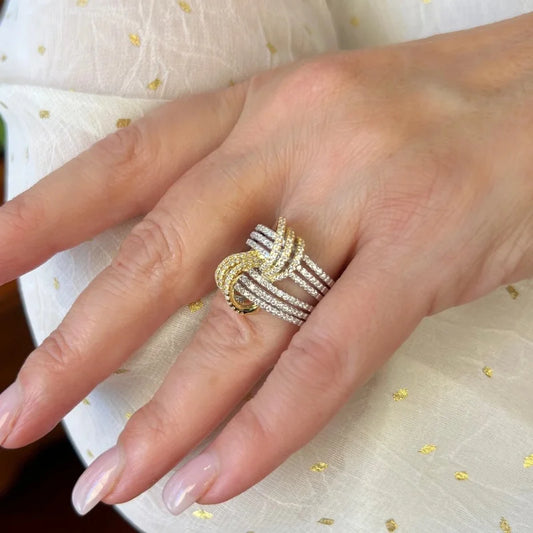 Two-tone silver and gold cubic zirconia statement ring worn on hand with stacked rails