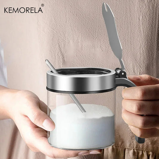 Glass seasoning jar with stainless lid and spoon, clear body and black handle grip