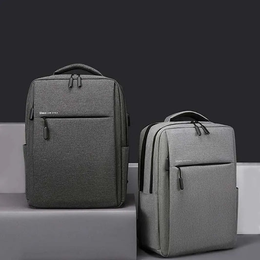 Dark gray laptop backpack with front zip pocket and padded shoulder straps.