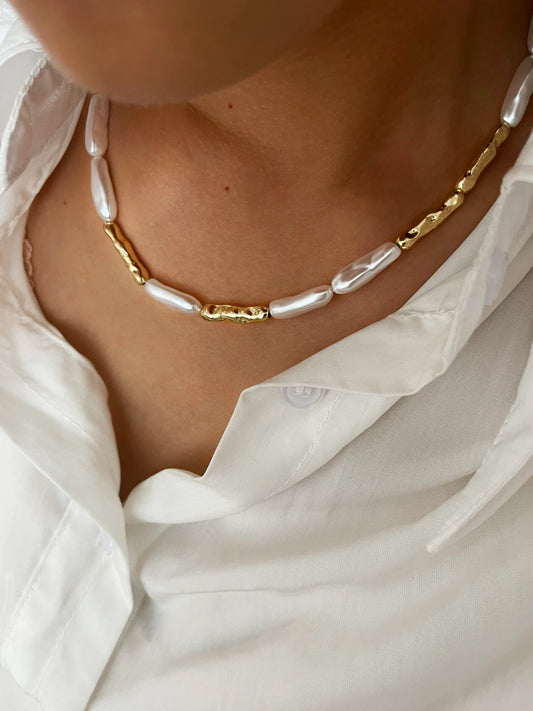 Gold-tone baroque pearl necklace with irregular white pearl links on a chain