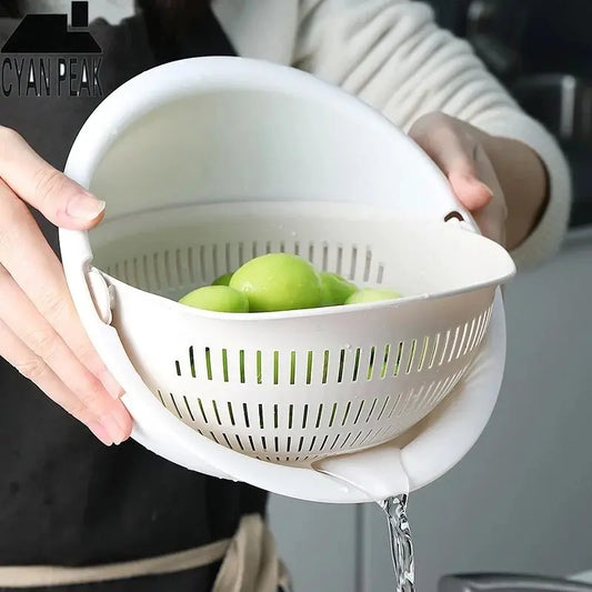 White double-layer fruit and vegetable draining basket with lid, holding green fruit