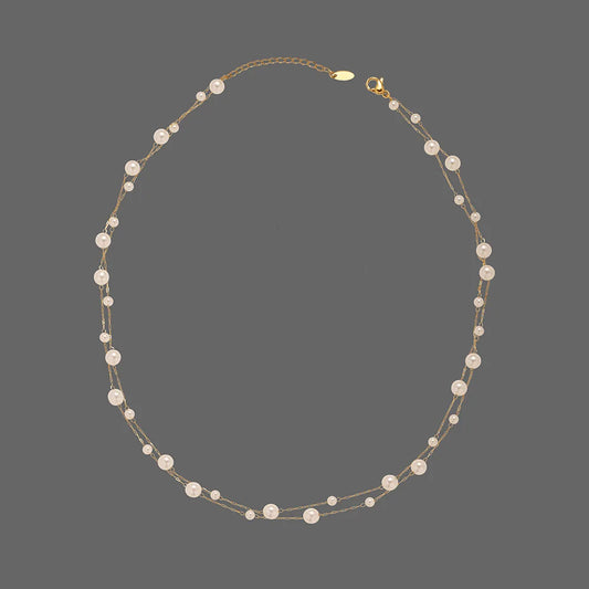 Gold-tone pearl collar necklace with evenly spaced white round pearls