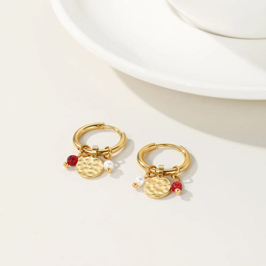 Gold hoop earrings with textured discs, red bead accents, and pearl bead charms