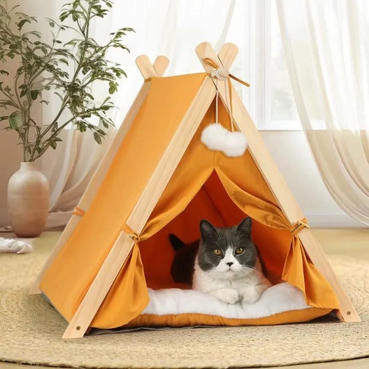 Portable pet teepee tent with orange canvas and white pom details, cat inside
