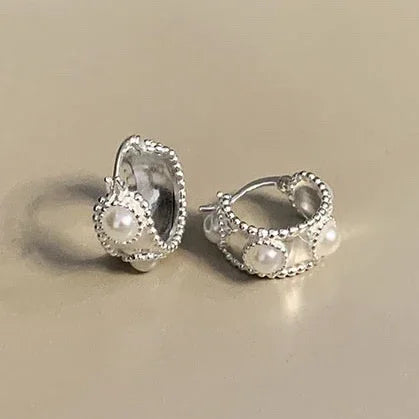 Silver hoop earrings with pearl bead charms and textured metal edges