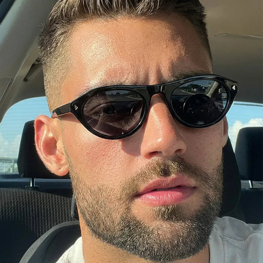 Black cat-eye sunglasses with dark lenses and glossy angular frame detail