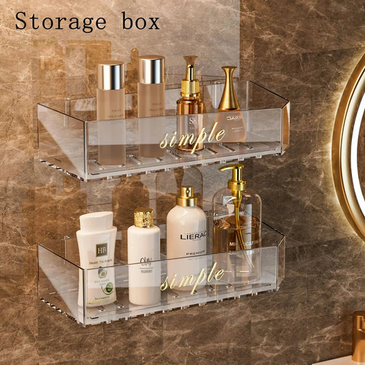 Two-tier clear acrylic bathroom storage rack with gold side rails for toiletries.